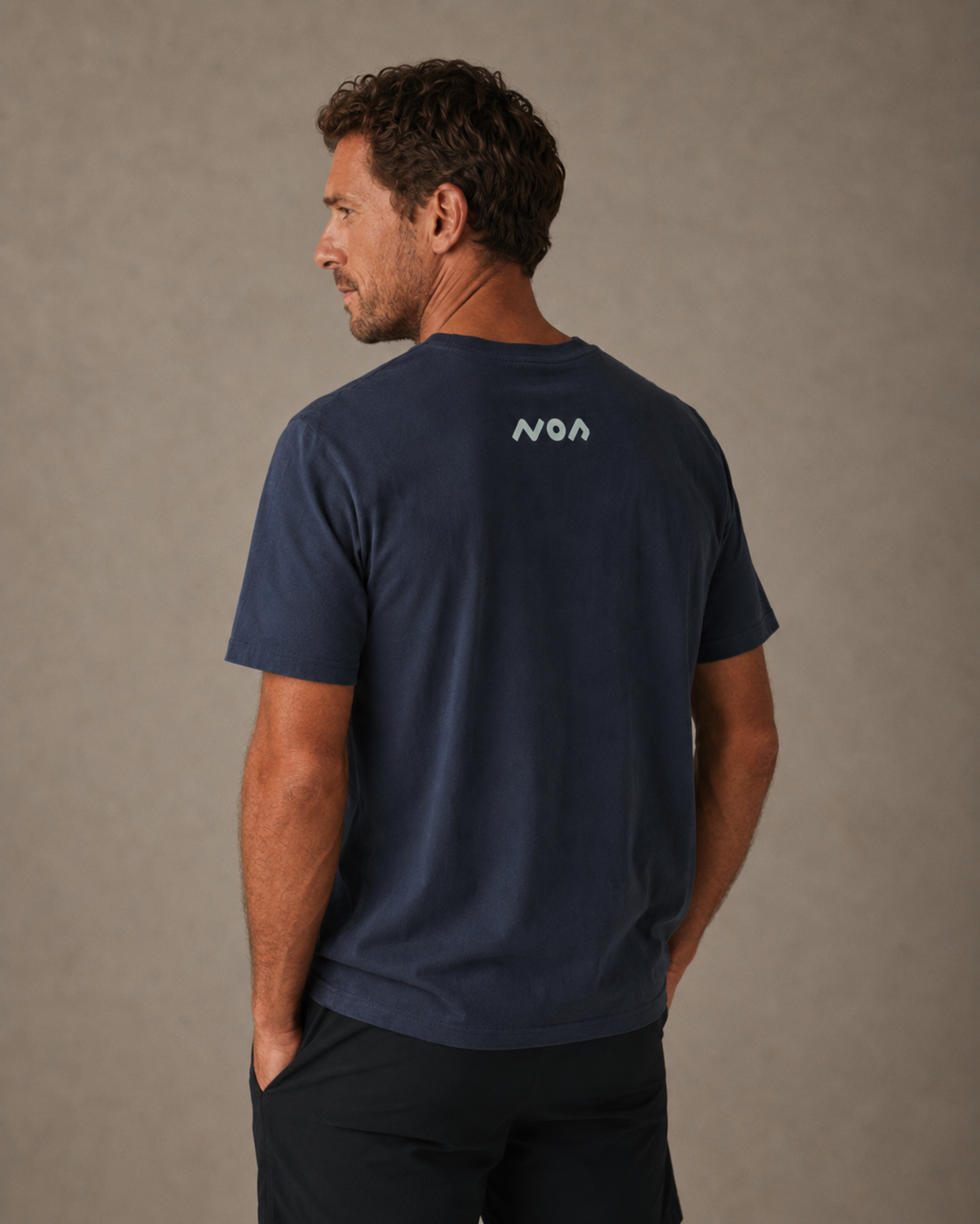 Male model wearing navy blue tee with back graphic